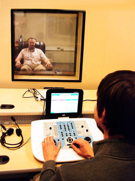 Ian Mertes looking through window at test subject sitting in easy chair